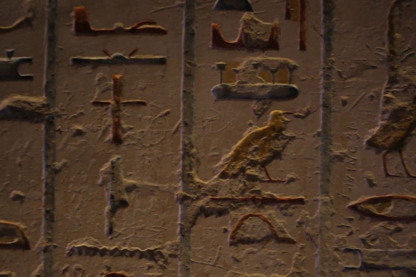 Hieroglyphics inside an Ancient Egyptian tomb. Pan to young woman. Located  in the 'Valley of the Kings.' 1080p HD. LUXOR, EGYPT - NOVEMBER 22, 2012.