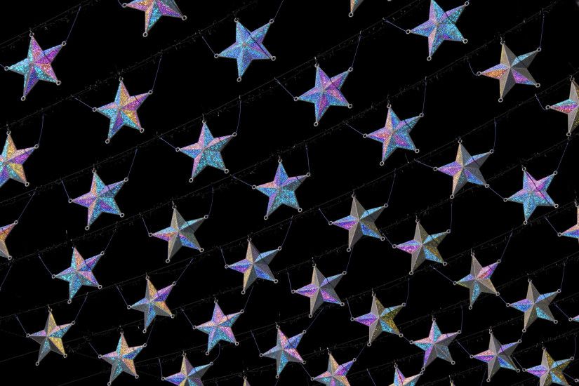 Christmas star background with diagonal rows of silver stars with a purple  hghlight on a black
