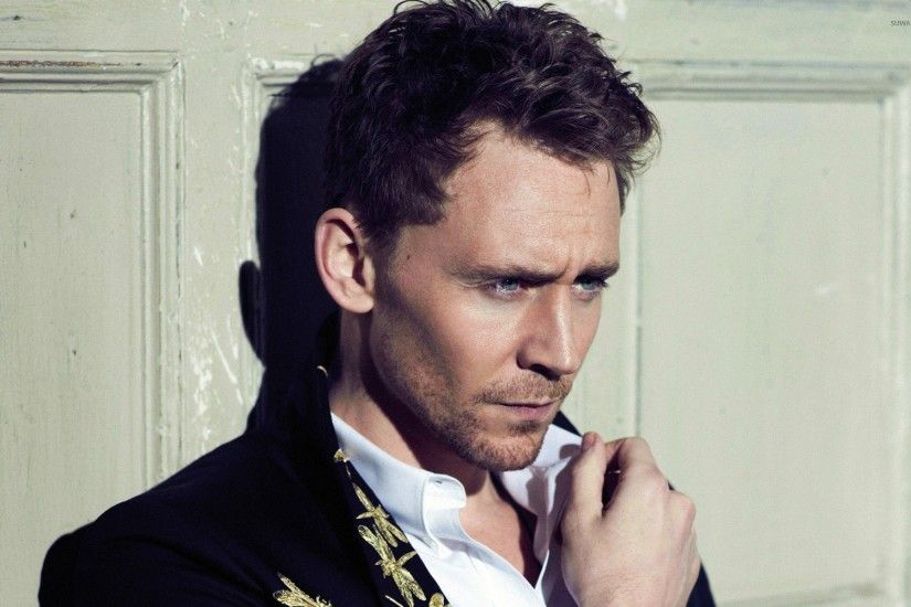 Tom Hiddleston in front of a wooden door wallpaper