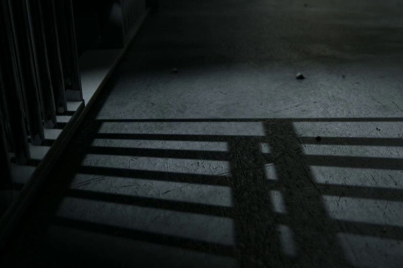 A static camera closeup showing a dimly lit floor of a prison cell and the  cast shadows of the door slamming shut Motion Background - VideoBlocks