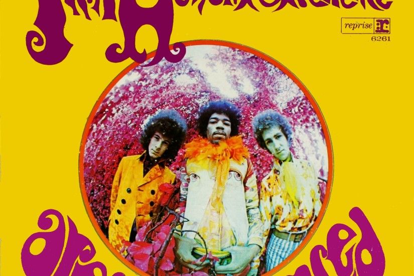 A color image of three men standing together wearing psychedelic clothing.