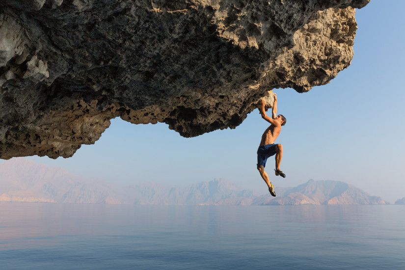Determined to finish a new route, superclimber Alex Honnold dangles from an  overhang on Oman's