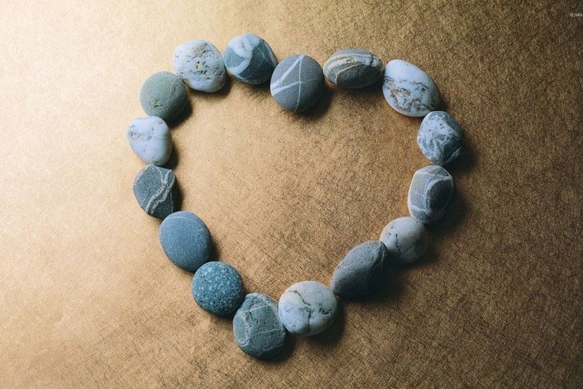 Pebbles shaping a blue heart wallpaper