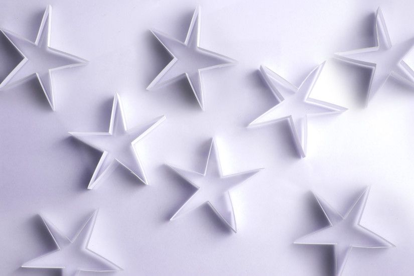 Scattered paper stars on a white background form a lovely delicate backdrop  for your Christmas message