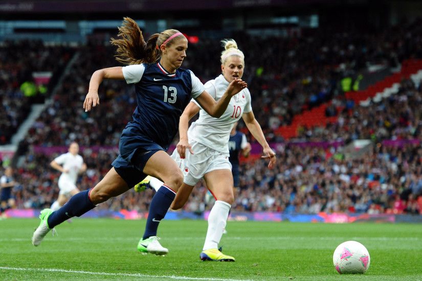 US forward Alex Morgan (L) and Canada's defender Lauren Sesselman compete  during the London