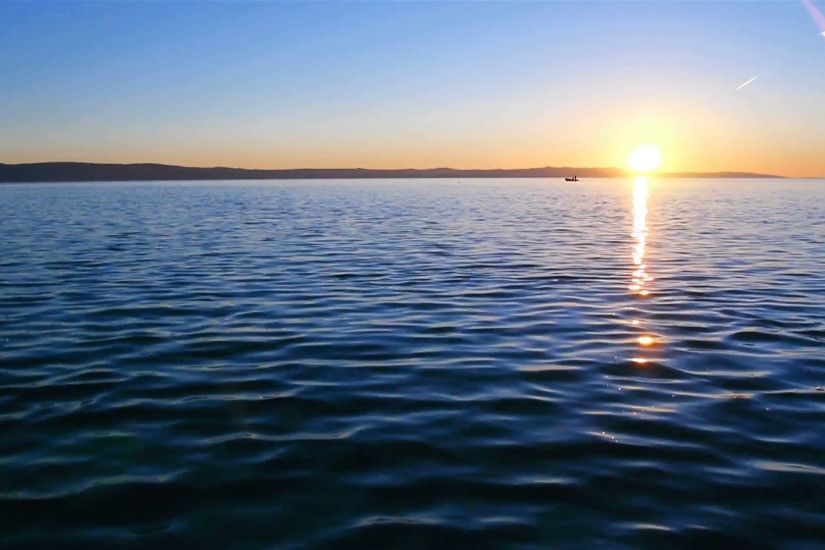 Peaceful scene of sunset on calm blue sea with fishermans in background  Stock Video Footage - VideoBlocks