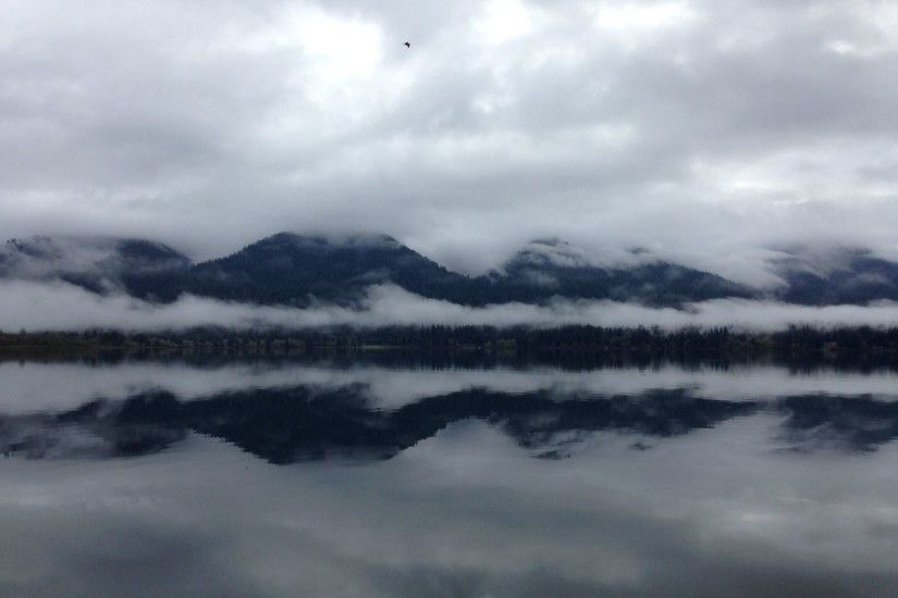 lake reflecting mountains and clouds