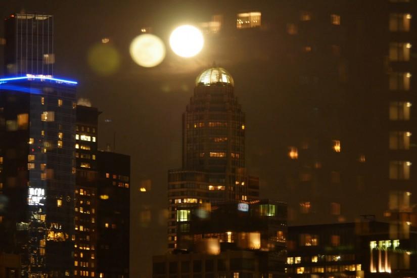 moon raising over city at night sky. urban lights background Stock Video  Footage - VideoBlocks