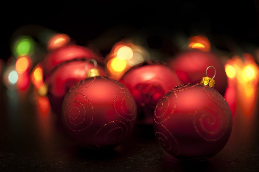 Dark colourful Christmas background or red baubles reflecting festive  lights with shallow dof and blur