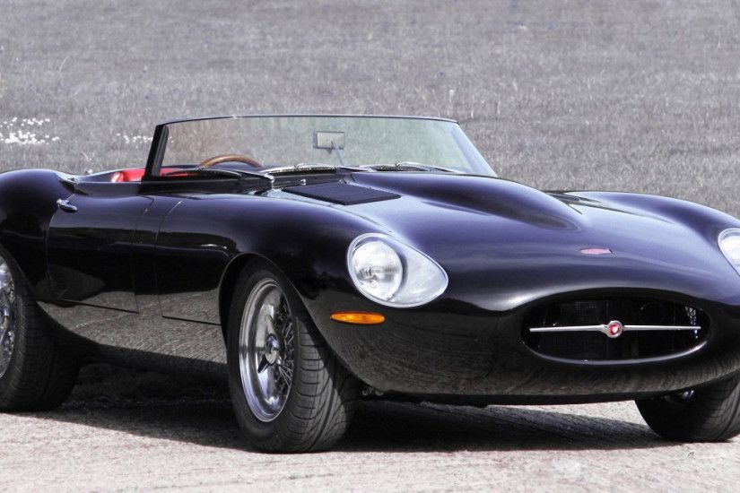 Black convertible Jaguar E-Type stands on the pavement without driver