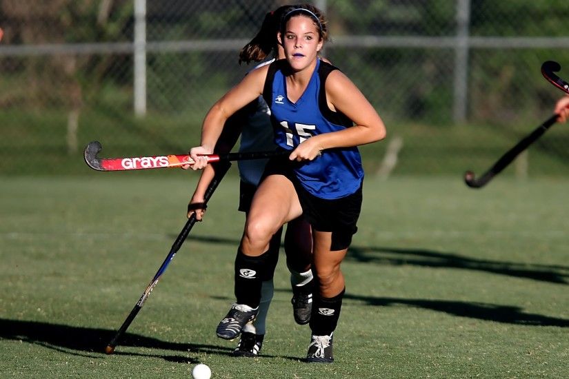 Woman Wearing Blue and Black Jersey Holding Field Hockey