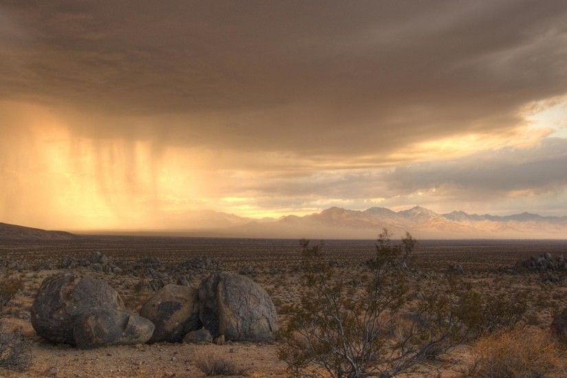 Rain clouds wallpaper moving across a desert.