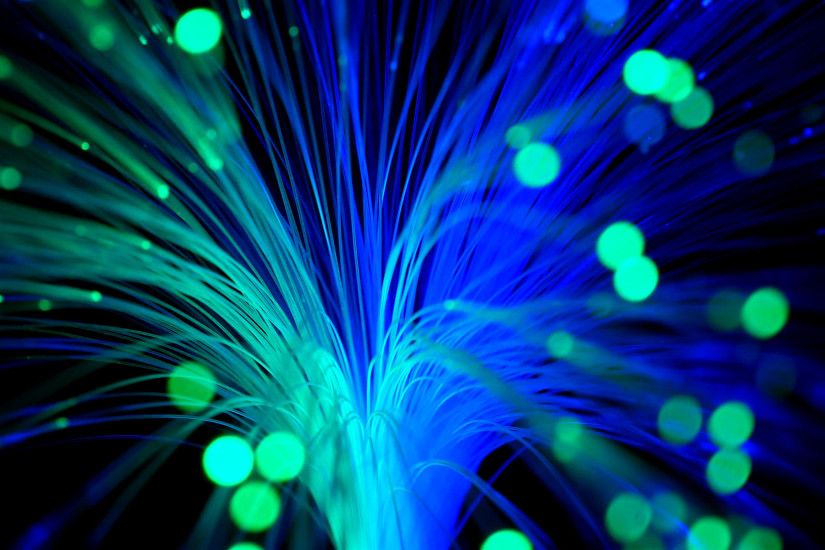 Subscription Library Green and blue fiber optics strands moving against a black  background.