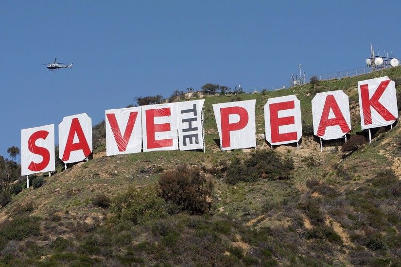 A helicopter flies over the iconic 450-foot-long Hollywood sign after  activists covered
