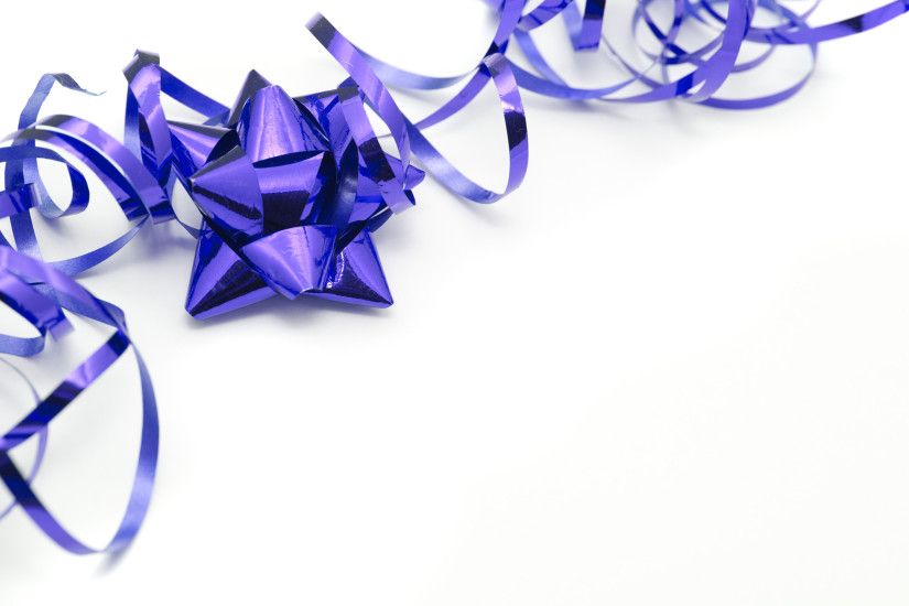 Purple festive corner border on a white background with copy space with a  twirled party ribbon
