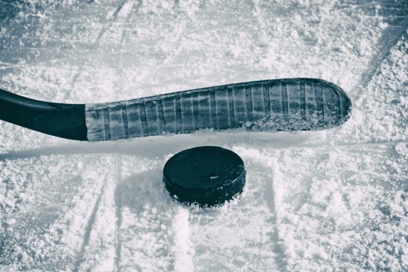 Hockey stick and puck on the ice wallpaper