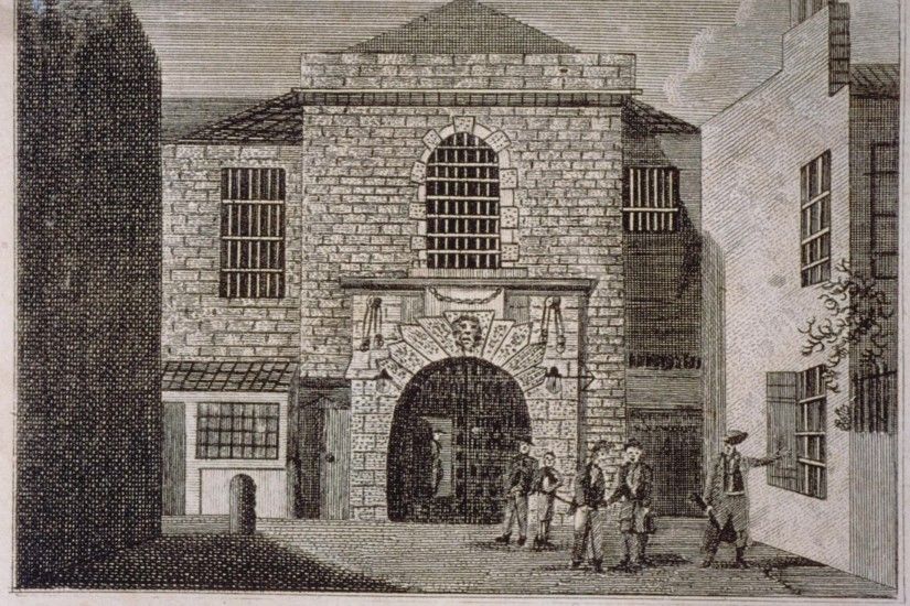 A view of the stone built frontage and main gate of New Prison, with several