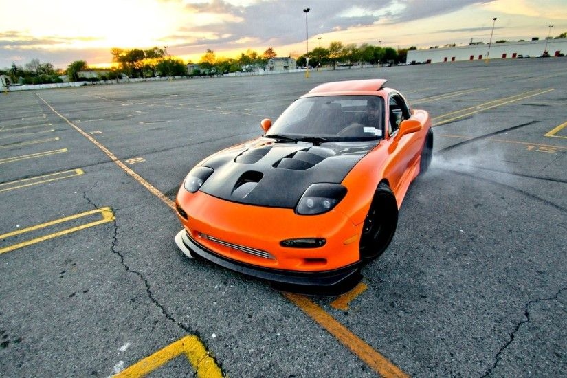 Orange Mazda RX-7 with a black hood