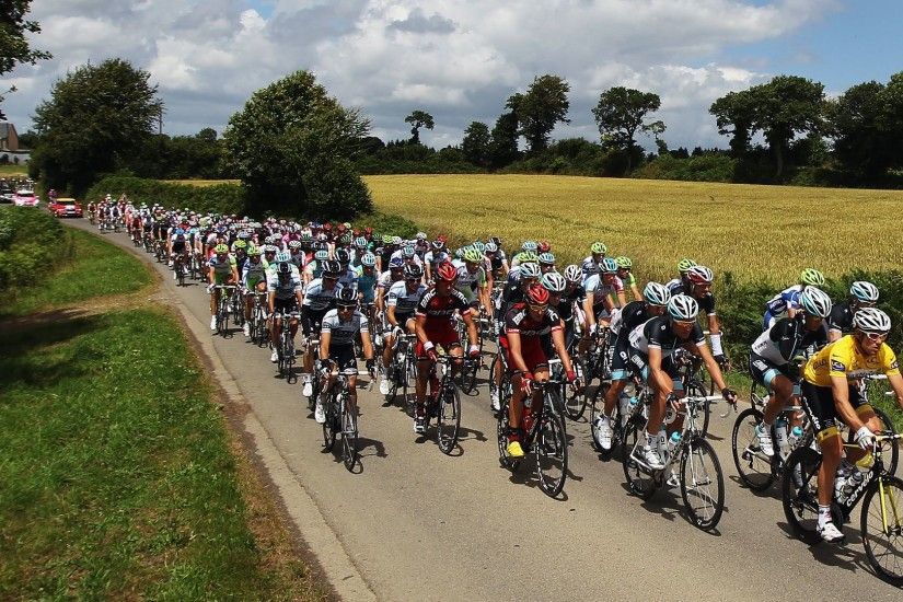 Tour de France riders cycle along the countryside.