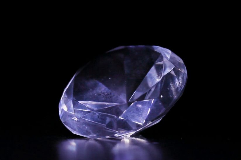 One big diamond stone rotating over dark background