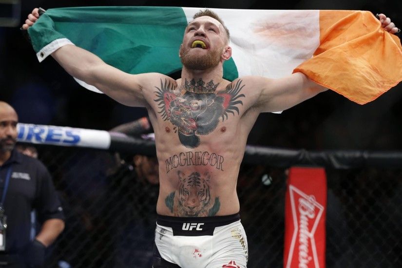 Conor McGregor (blue gloves) celebrates after defeating Eddie Alvarez (red  gloves) in their lightweight title bout during UFC 205 at Madison Square  Garden.