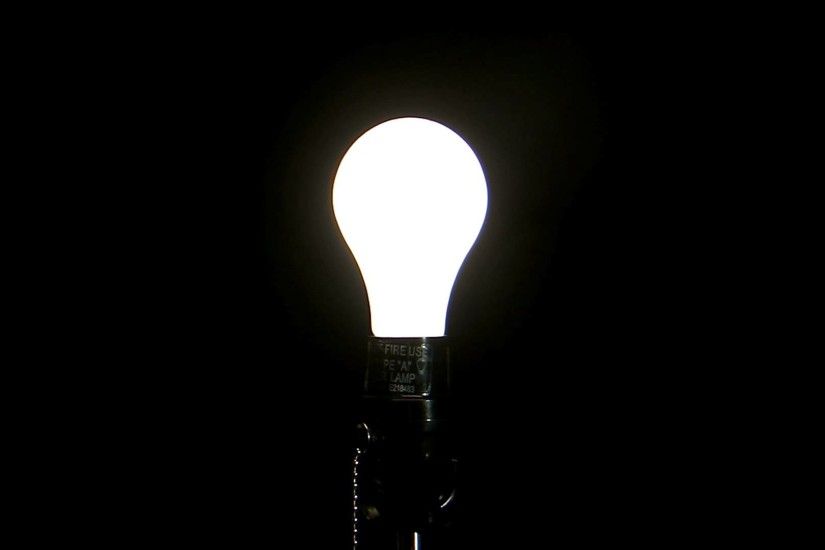 light bulb in the darkness. light bulb turning on against a black background  hd stock
