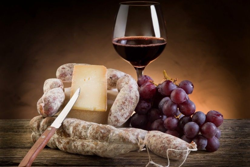 glass wine red grapes bunch of cheese hunk knife salami
