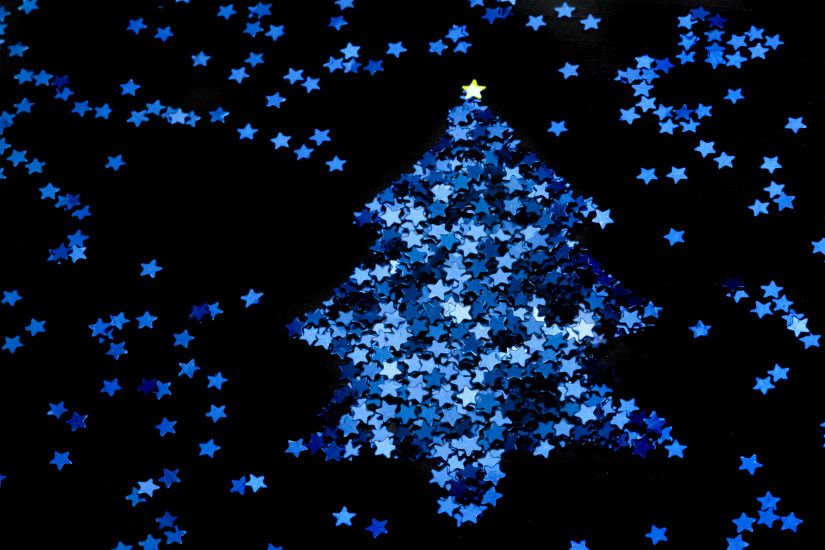 Christmas star tree made from a myriad of tiny blue stars on a black  background