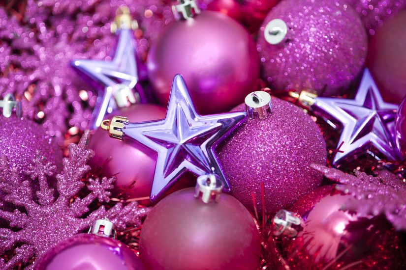 a festive holiday background with pink coloured glittery christmas tree  ornaments on a bed of sparkling