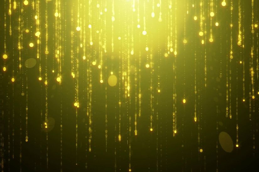 Falling gold particles flicker and shimmer against a black background.  Abstract background for fashion glamor